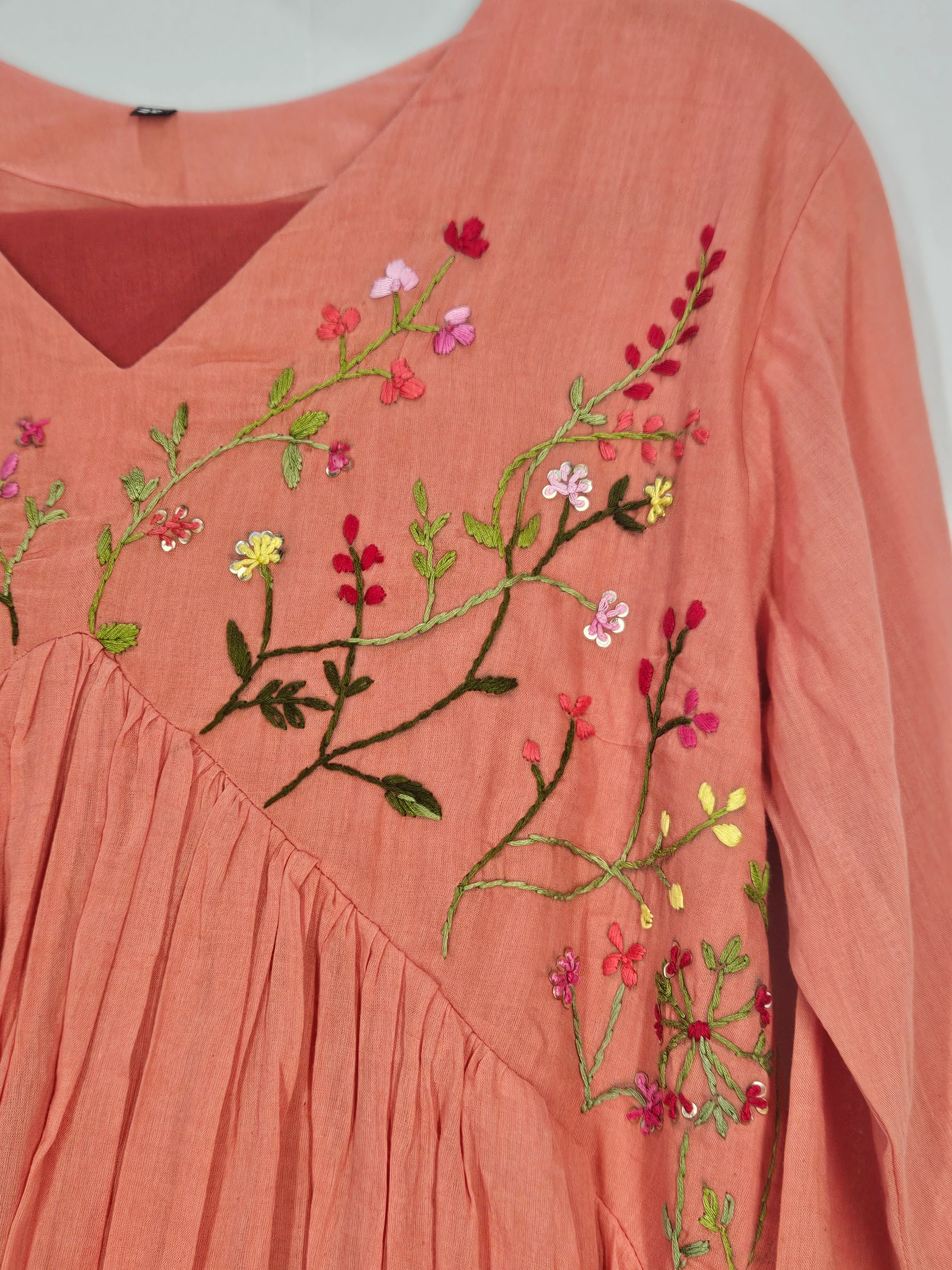 Pure mul cotton 2-piece ethnic set in peach with intricate floral embroidery in vibrant green, pink, and yellow hues.