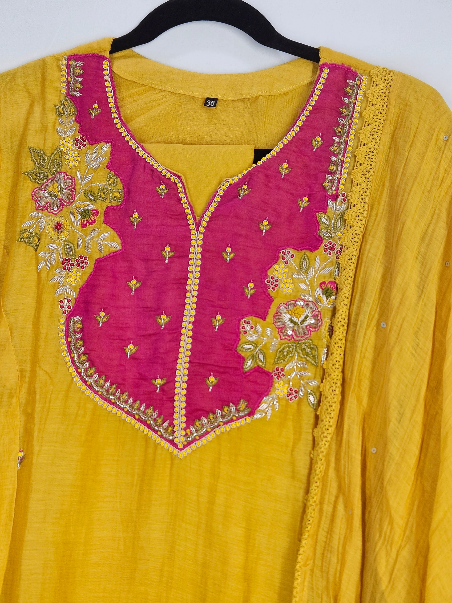 Mustard yellow Chanderi silk suit with pink embroidered yoke featuring floral motifs, beadwork, and delicate detailing, perfect for festive and wedding wear.