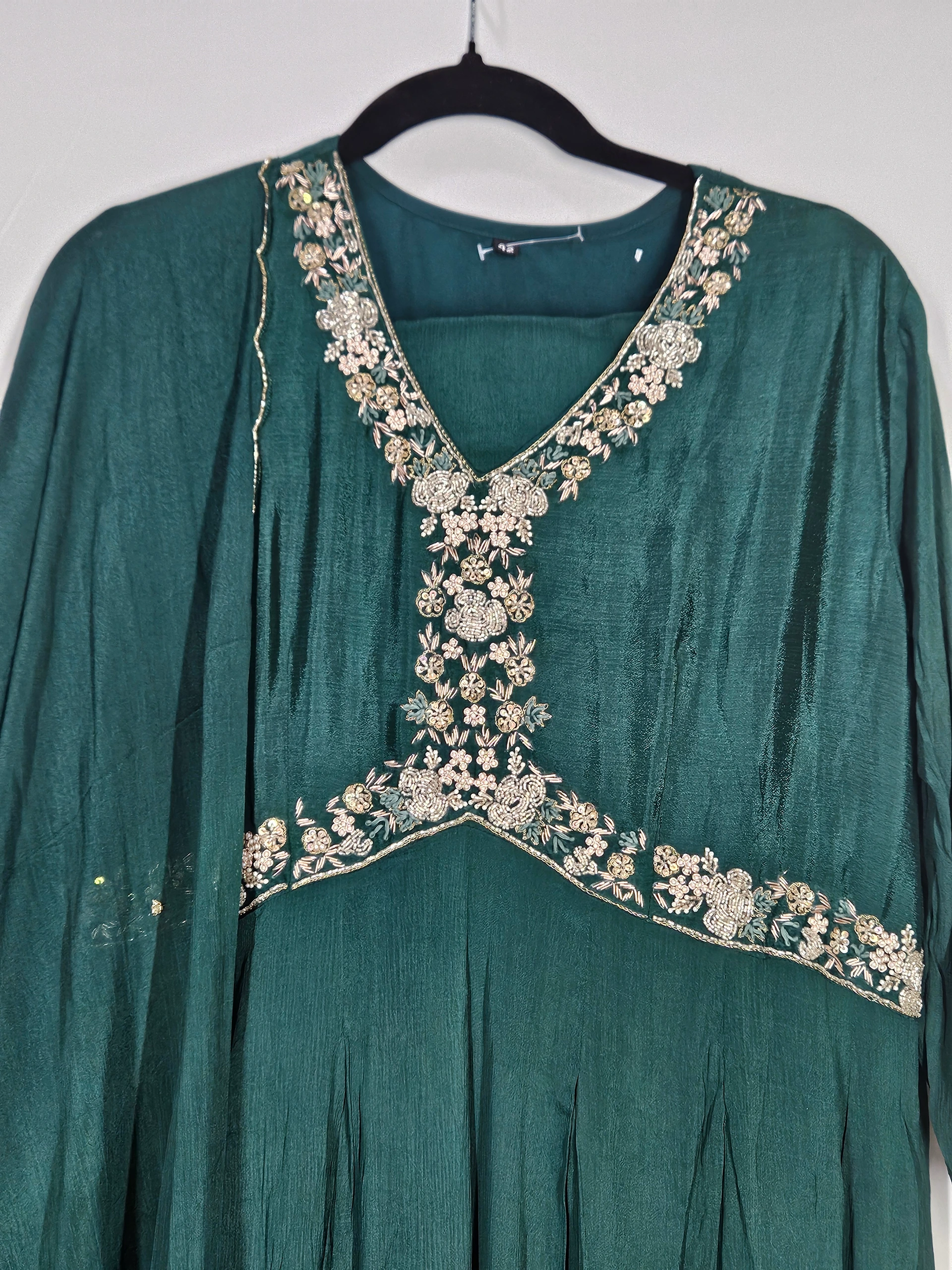 Elegant pure chinon Anarkali gown in deep green with intricate golden floral embroidery on the neckline and yoke, perfect for weddings and festivals.