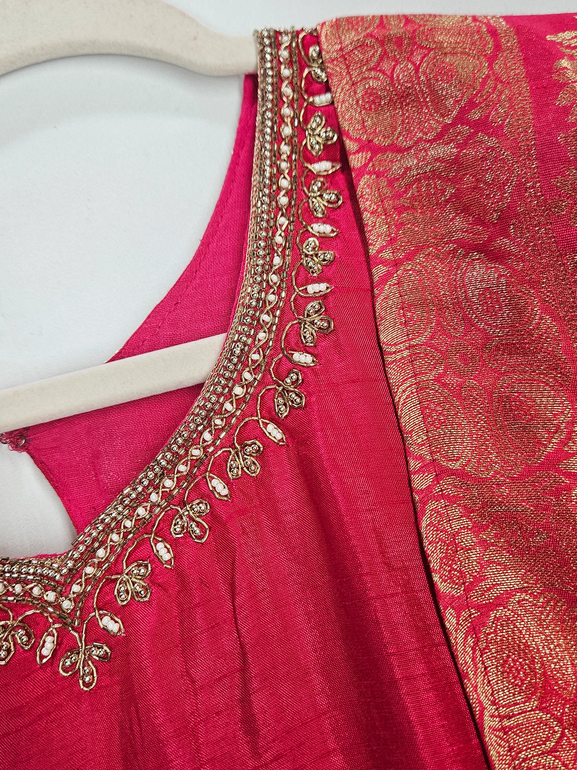 Pure Dola Silk ethnic dress in vibrant pink with intricate gold zari work and delicate bead embellishments on the neckline.