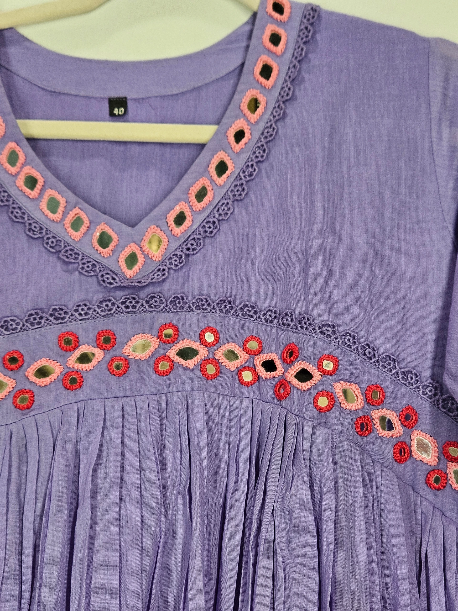Handcrafted pure mul cotton frock in lavender with intricate pink and red embroidered patterns on the neckline, offering breathable and elegant ethnic wear.
