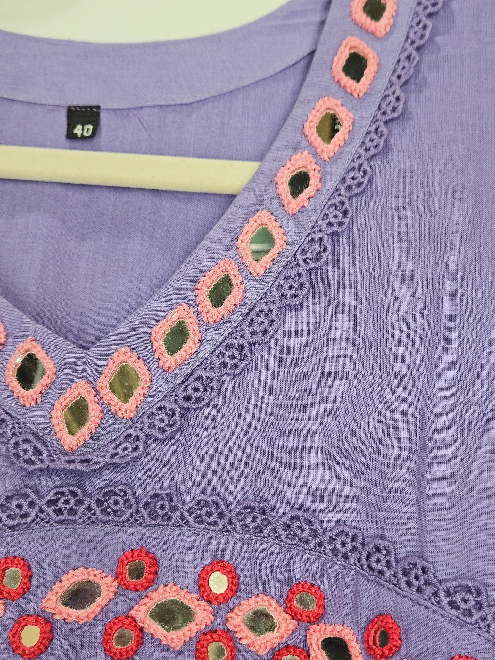 Handcrafted pure mul cotton frock in lavender with intricate pink and red embroidered patterns and lace detailing. Perfect for elegant ethnic wear.