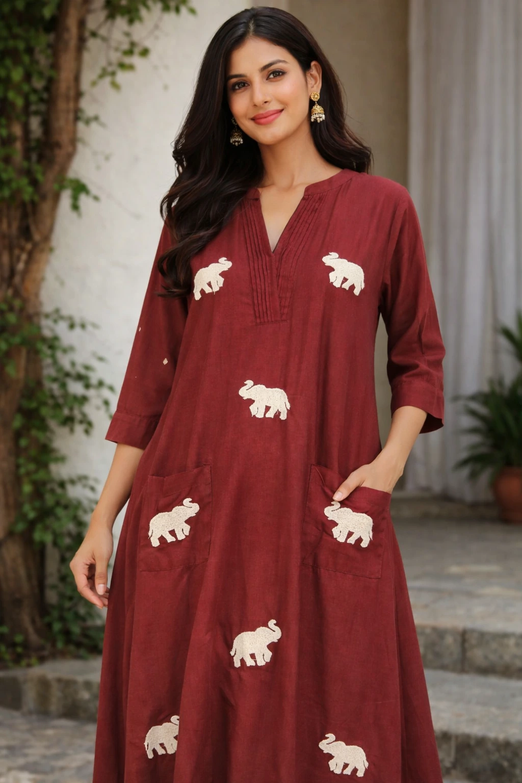 Maroon pure mul cotton frock with white elephant motifs, featuring a V-neckline, three-quarter sleeves, and side pockets, perfect for casual ethnic wear.