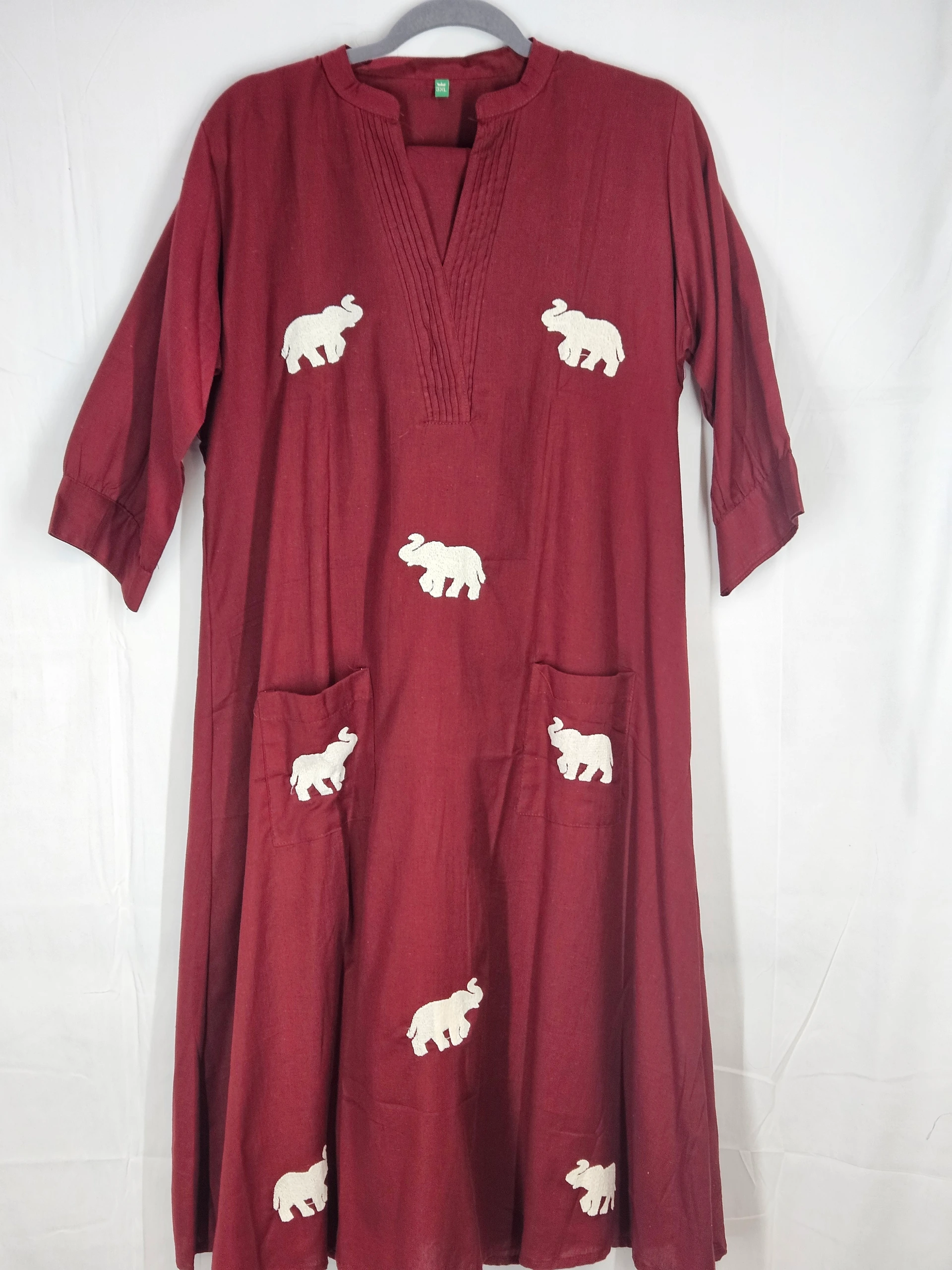 Maroon pure mul cotton frock with white elephant motifs, V-neck, three-quarter sleeves, and front pockets; breathable and elegant design.
