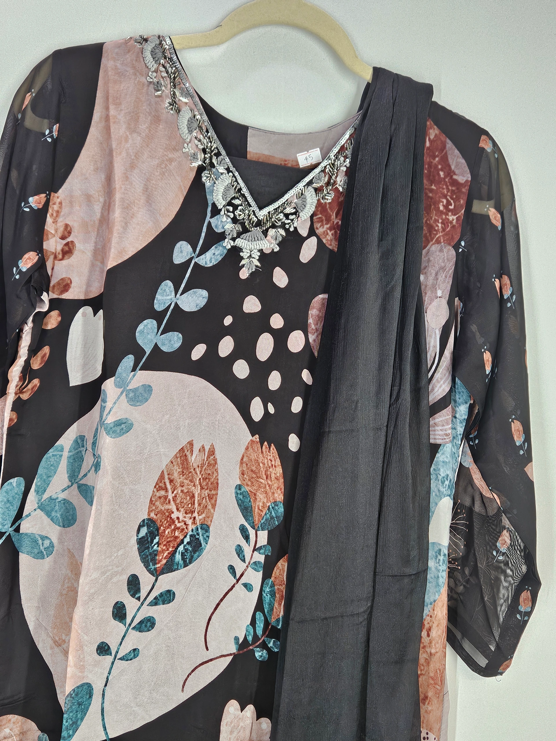 Pure georgette ethnic gown in black with floral prints, silver embellishments on the neckline, and matching dupatta, ideal for weddings and festivals.