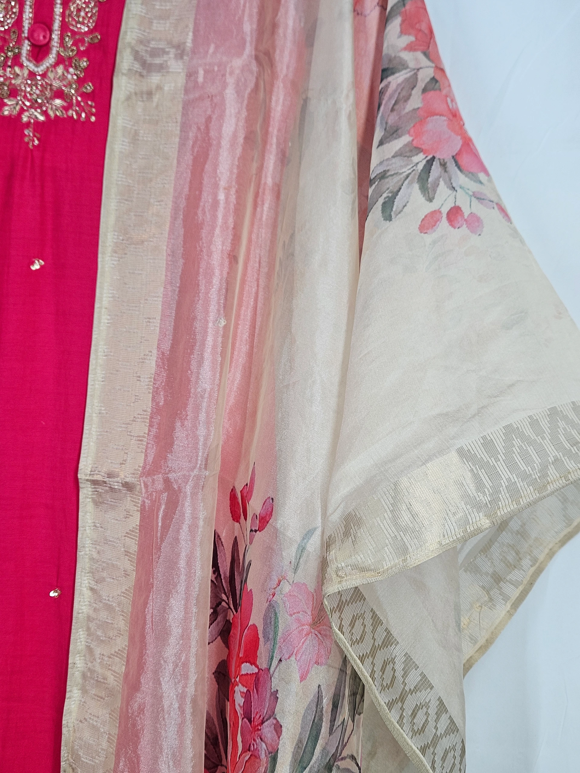 Elegant pure muslin ethnic dress in vibrant pink with intricate embroidery, paired with a beige dupatta featuring floral prints and subtle patterns.