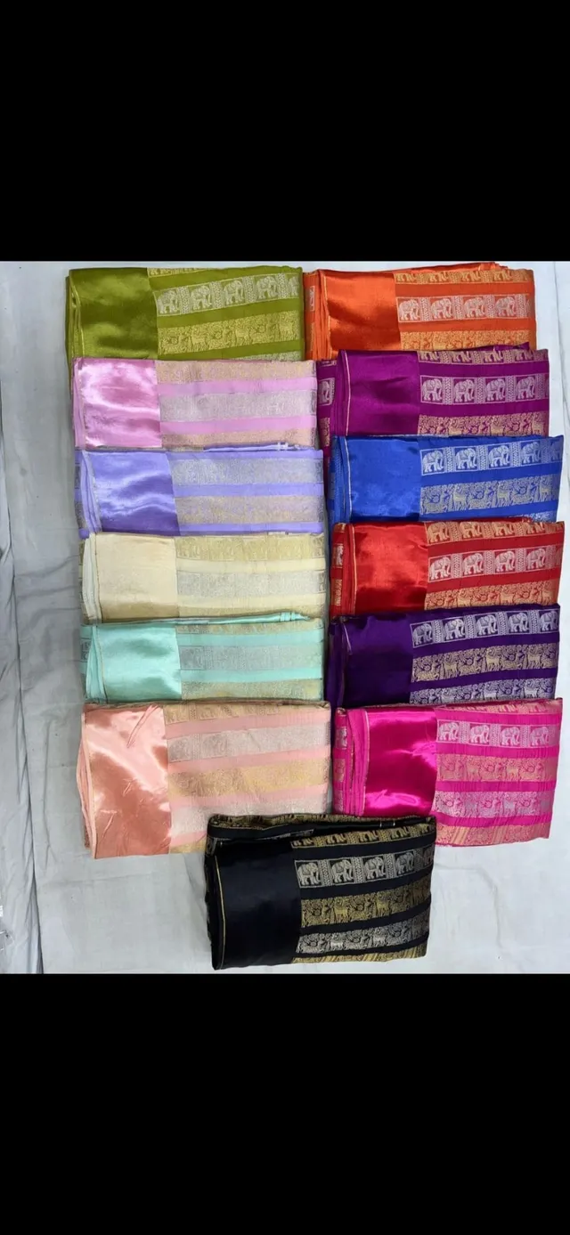 Assorted Russian crape silk sarees in vibrant colors with gold zari borders, displayed folded on a white surface.