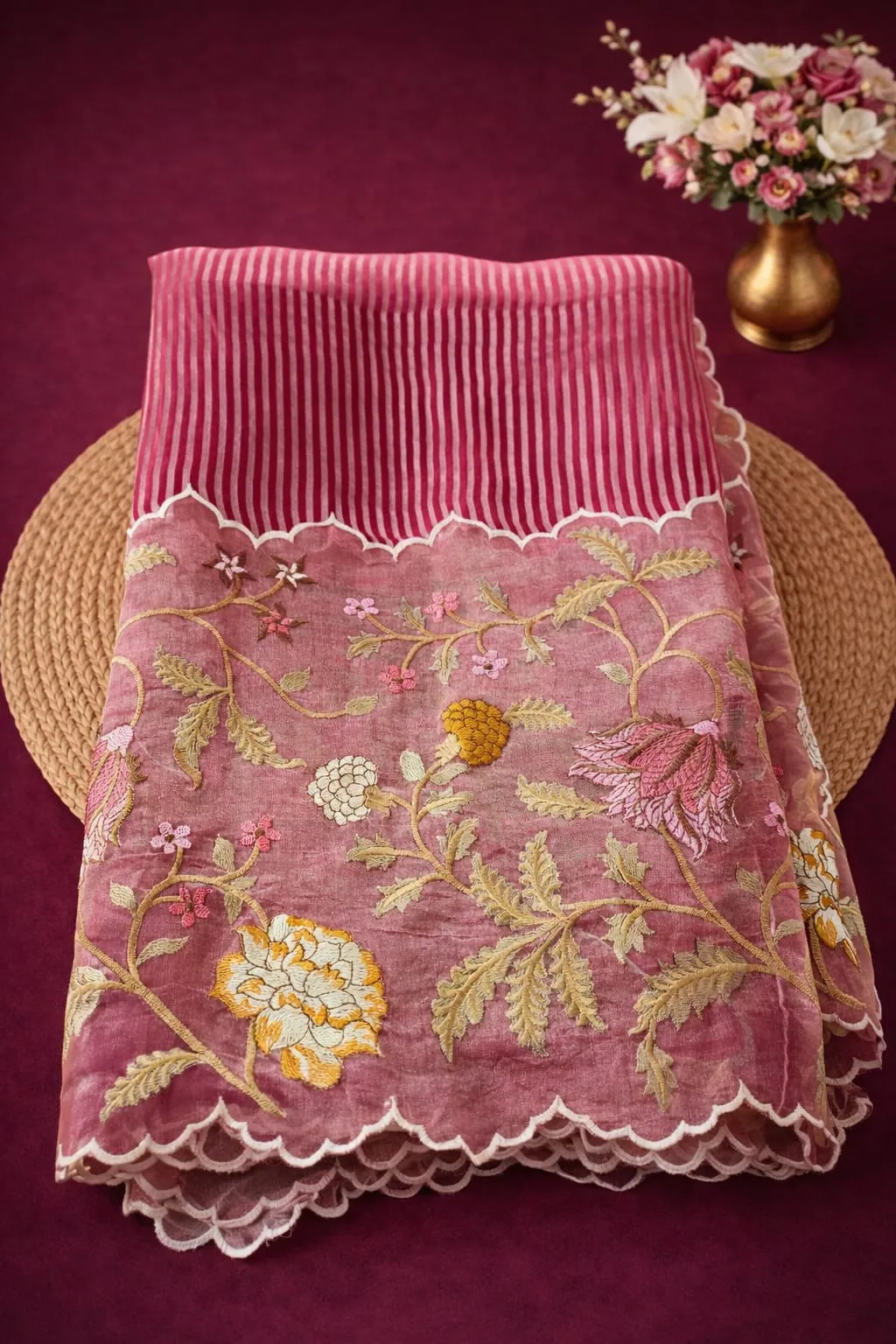 Pure Banarasi Kora Tissue saree in golden pink with intricate floral embroidery and scalloped border, displayed on maroon background.
