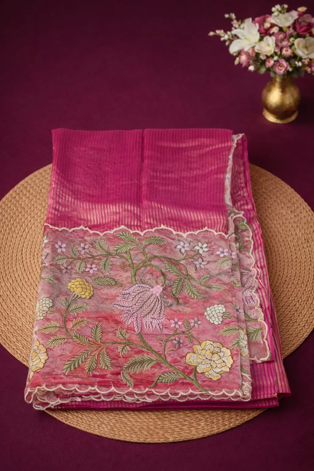 Elegant pink Banarasi Kora tissue saree with lustrous finish, floral zari embroidery, and scalloped border on display.